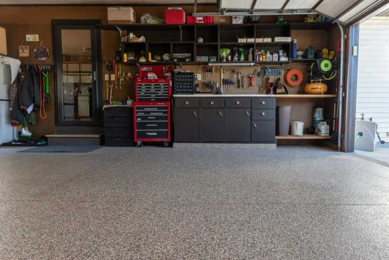 Finished garage floor coating in a garage with a toolbox and other storage.